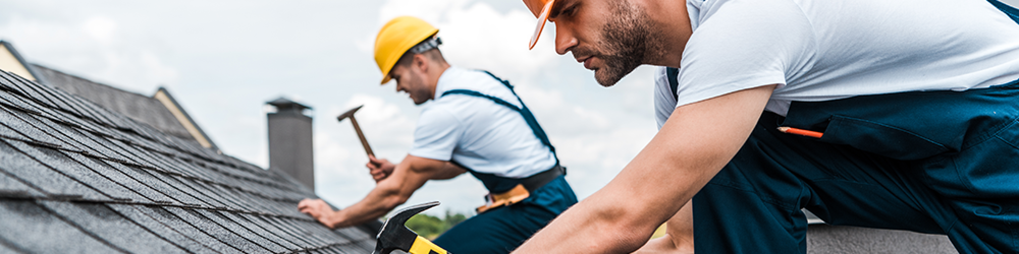 What are leasehold service charges? Explained by SAM conveyancing. Two workers in hard hats and overalls nail tiles to a roof