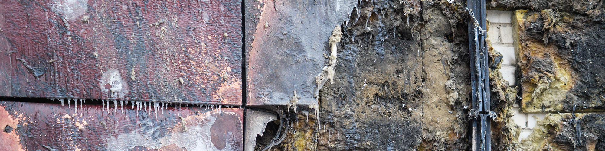 The fire damaged exterior of a panel clad apartment building. SAM Conveyancing's guide on Staircasing or Remortgaging with dangerous cladding 