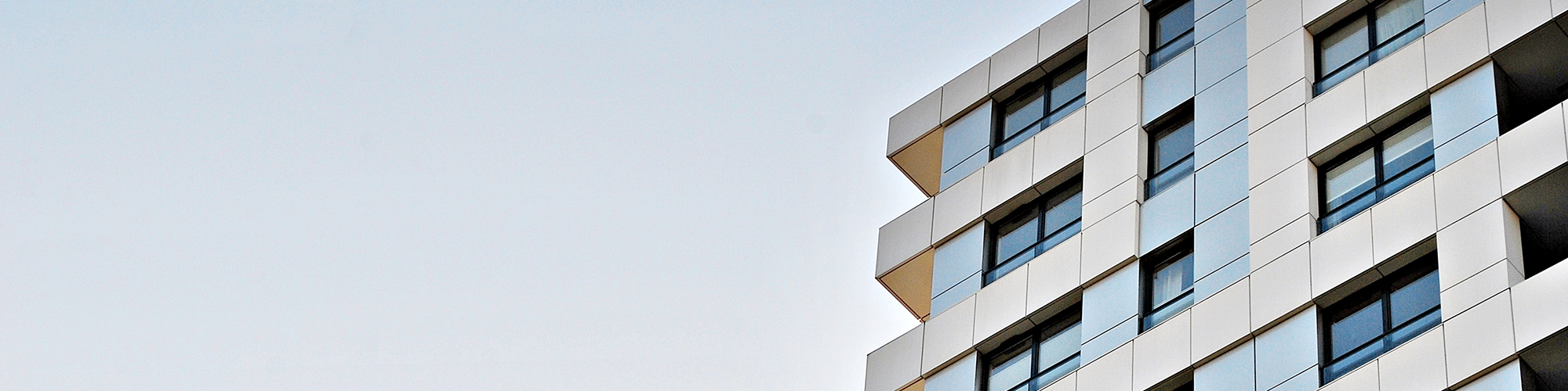 A block of leasehold flats against a clear sky. SAM Conveyancing explain: What is a Leasehold Management Company and how you can get rid of one