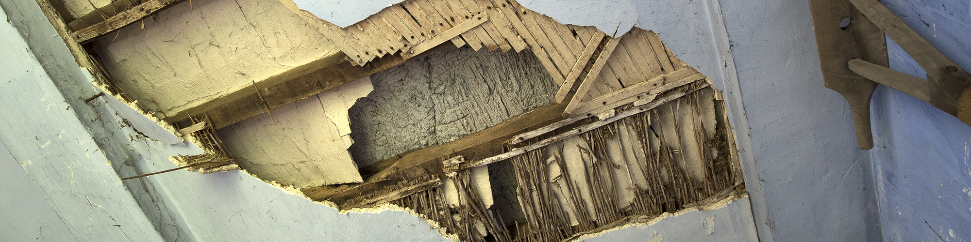 A partially collapsed ceiling revealing traditional lath and wattle under the plaster. SAM Conveyancing describe how to detect potential problems and prevent Lath and Plaster Ceiling Collapse