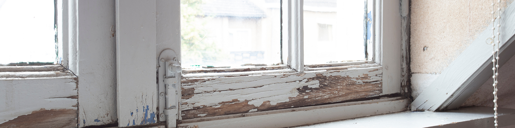 Chipped paint and cracked wood on window. SAM Conveyancing's guide on handling a rotten window frame