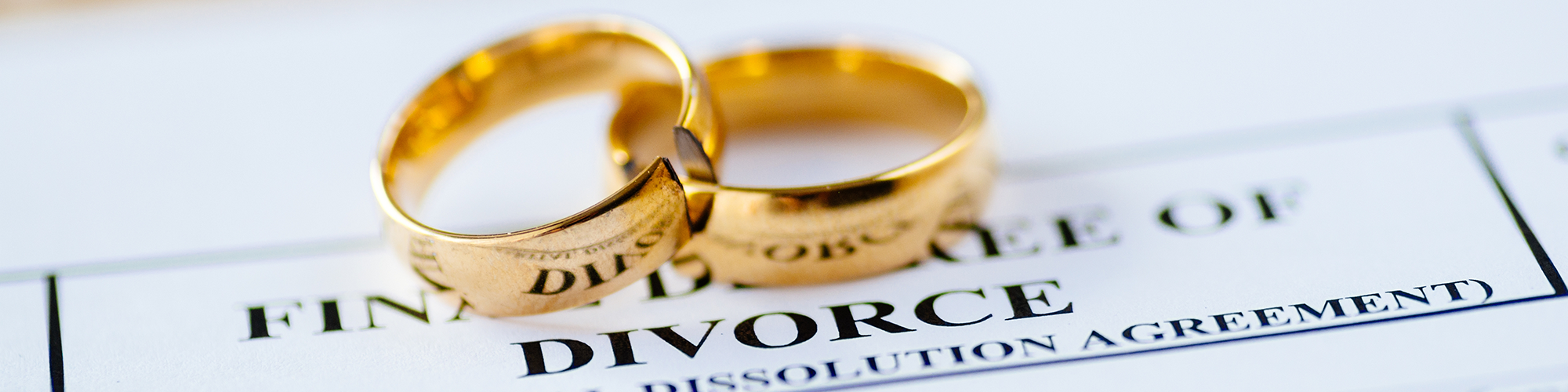 Two cut wedding bands sit on top of divorce papers. Who Gets the House in a Divorce/Dissolution? A guide from SAM Conveyancing
