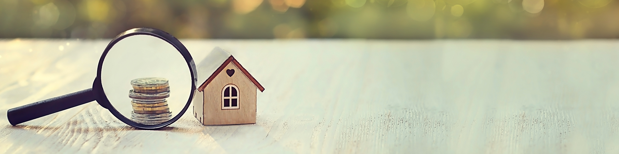 Applying for a mortgage? 3 things you can't have on your bank statement - From SAM Conveyancing. A looking glass scrutinises a stack of coins beside a wood-block toy house.