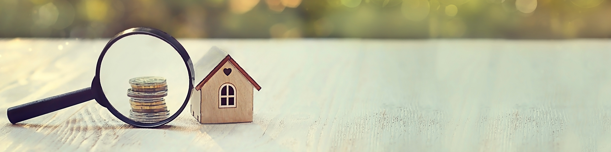 Bad Credit Mortgage - Getting a Mortgage with a CCJ, with SAM Conveyancing. A magnifying glass scrutinising a pile of coins next to a wood block toy house.