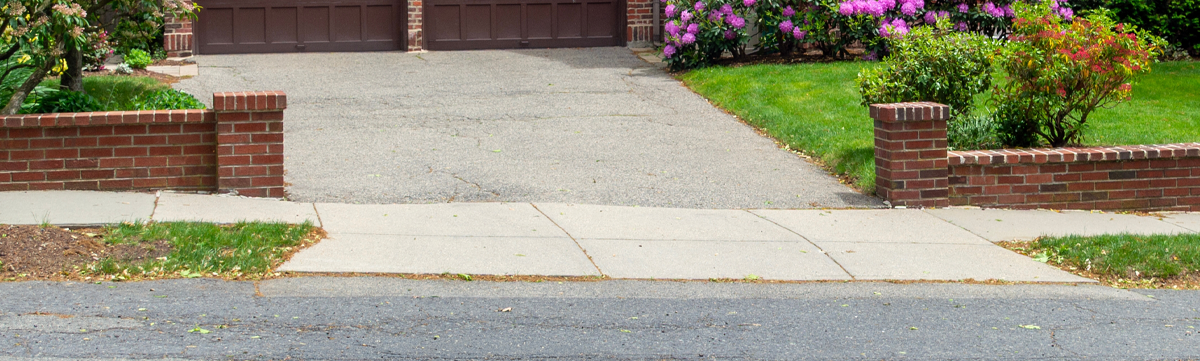 An official council approved dropped kerb serving a residential gravel driveway