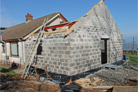 An extension being built. Wall removal prices can fluctuate depending on location and the type of wall being removed (internal load bearing wall or external). SAM Conveyancing explains the relevant building regulations