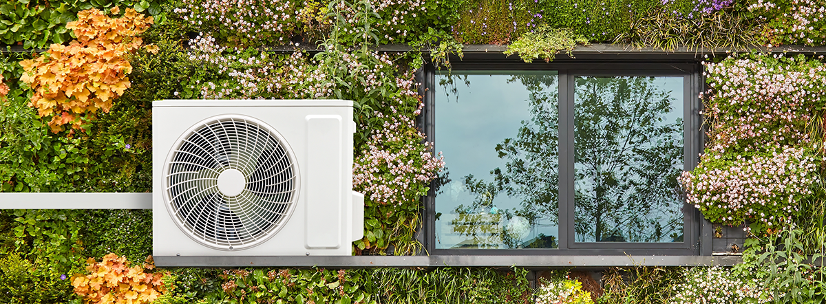 An air source heat pump on an green wall of a low-carbon house