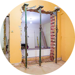 A partially demolished, load bearing wall supported by acro-props as part of renovations calculated by a structural engineer in a load bearing wall survey from SAM Conveyancing