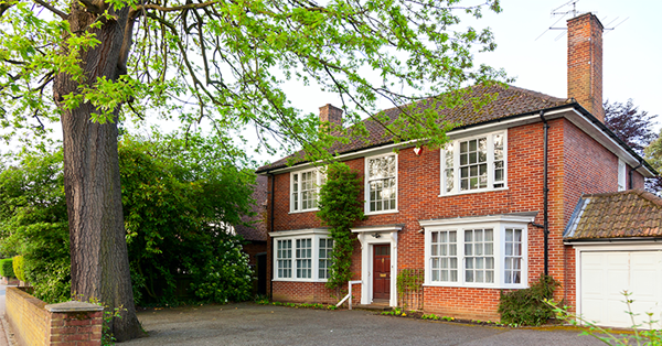 A typical detached UK home with a tree outside. SAM Conveyancing helps you gain valuable space whether that's a garage conversion, roof space, or a new heating system