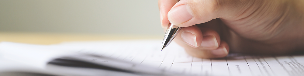 TA7 Leasehold Information Form explained by SAM Conveyancing. A photo of a hand holding a pen over a legal document, poised to write.