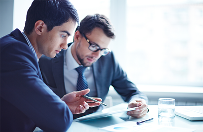Picture of two professionals looking at documents to compare online conveyancing quotes