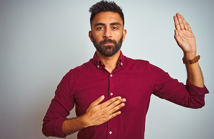 Statutory Declaration Solicitor from SAM Conveyancing: A man in a red shirt holds his right hand on his heart and his left hand up, palm facing forward